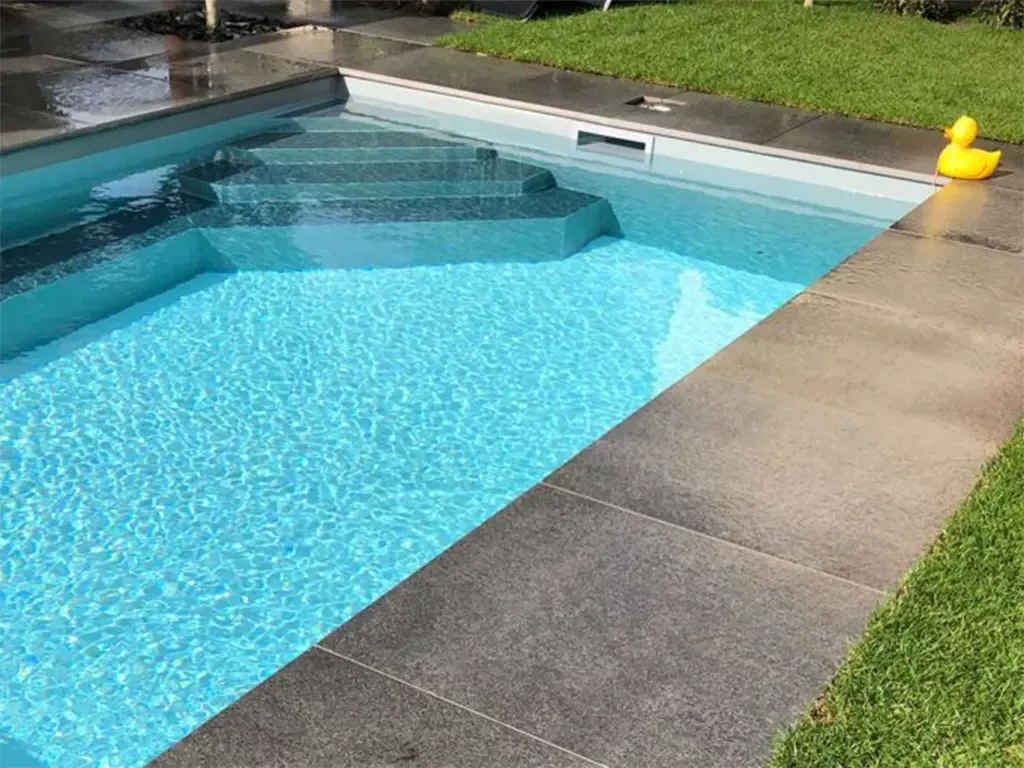 Moderne Poolumrandungen aus Steinplatten am Swimmingpool