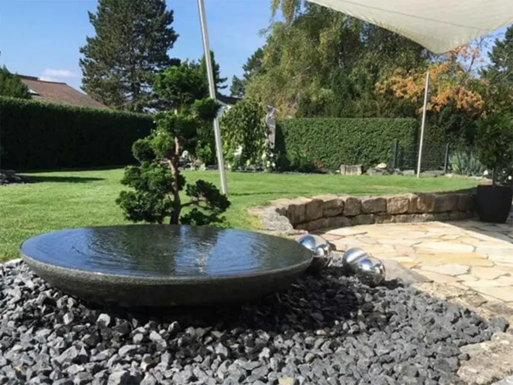 Dekosteine im Garten mit moderner Wasserschale und Zierkies als Gestaltungselement