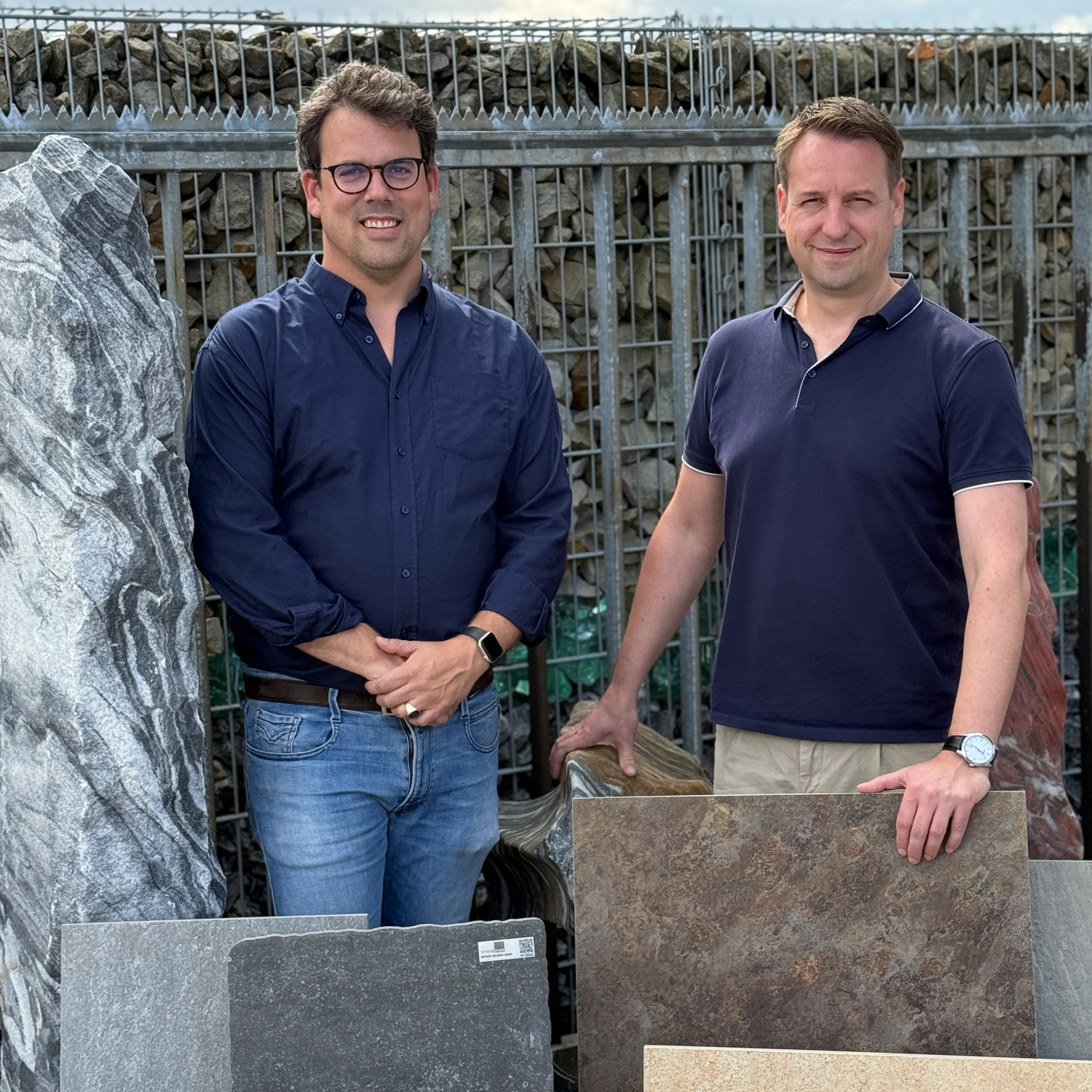 Marc und Christo präsentieren verschiedene Natursteinplatten im Außenbereich