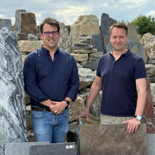 Marc und Christo stehen zwischen verschiedenen Natursteinplatten