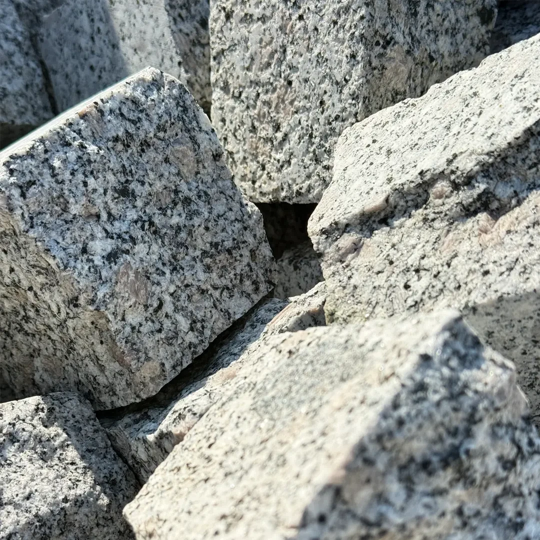 Nahaufnahme von Naturstein Pflastersteinen aus Granit, ideal für Außenanlagen und Wege