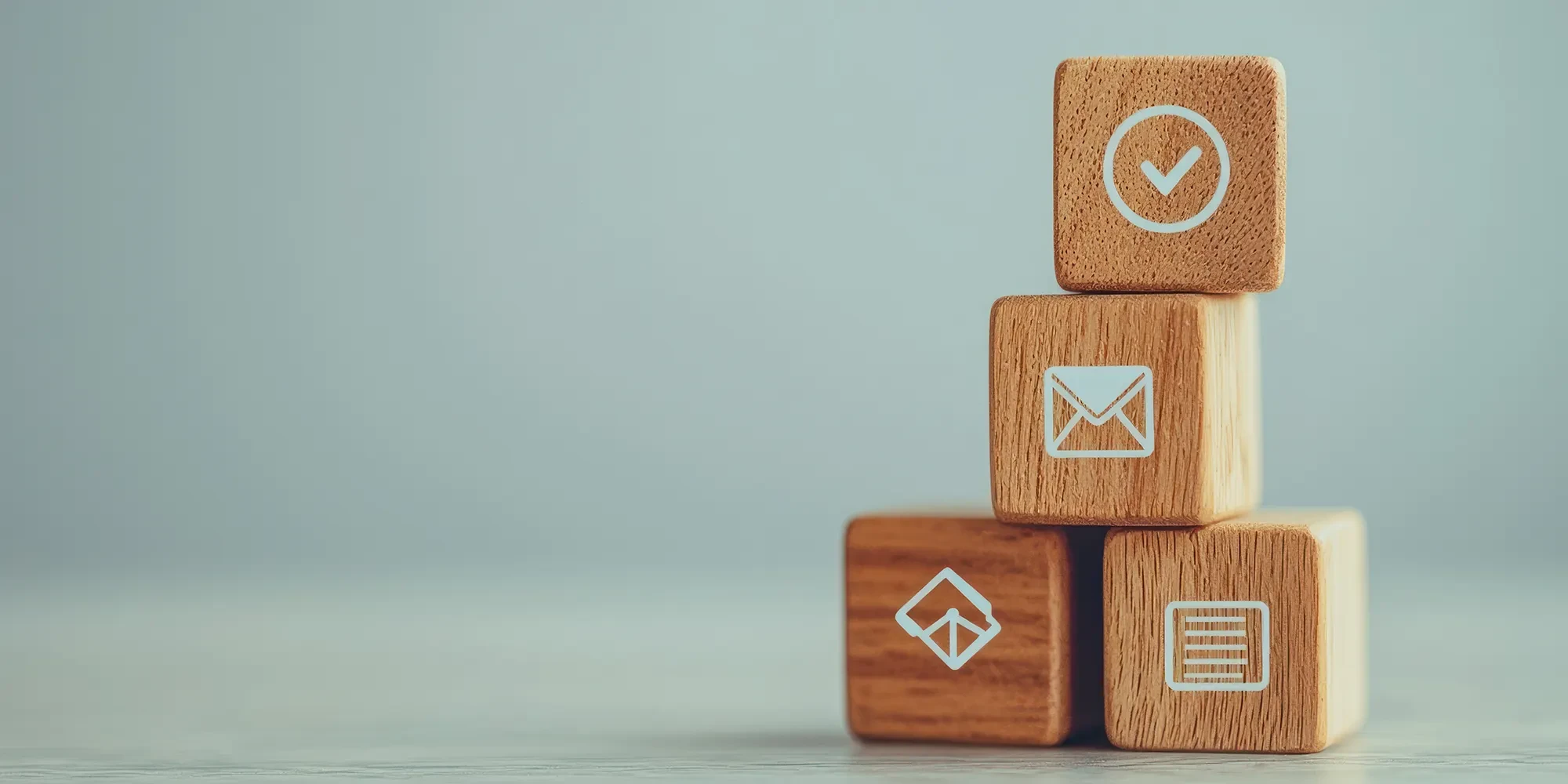 Header Kontakt: Symbolische Holzwürfel mit Brief- und Kontakt-Icons als Kontaktaufnahme-Motiv