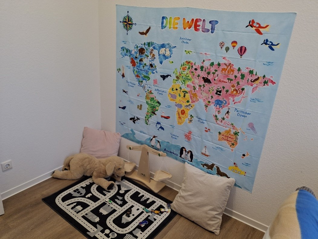 Kinderzimmer mit bunter Weltkarte und Spielecke mit Spielzeug