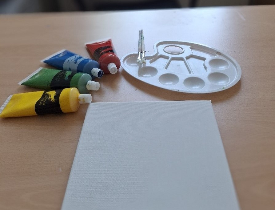 Malutensilien mit Farben, Pinseln und Palette auf einem Tisch