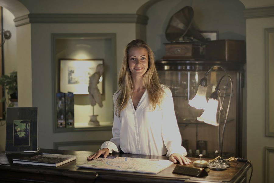 Rezeptionistin am Empfang eines Hotels mit antikem Dekor