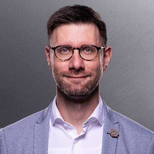 Porträt eines Mannes im grauen Sakko mit weißem Hemd Mann im grauen Sakko mit weißem Hemd vor grauem Hintergrund