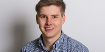 mrp Porträtfoto einer Person mit kariertem Hemd vor hellem Hintergrund