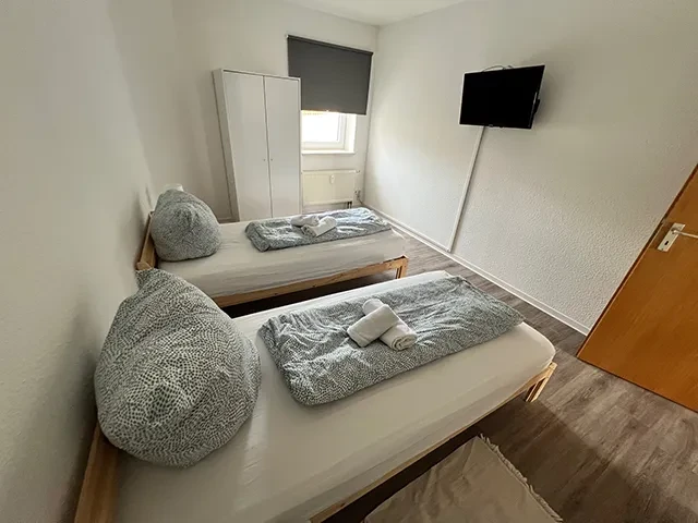 Apartment – modernes Zimmer mit zwei Einzelbetten und TV Modernes kleines Apartment mit zwei Einzelbetten, Kleiderschrank und Fernseher