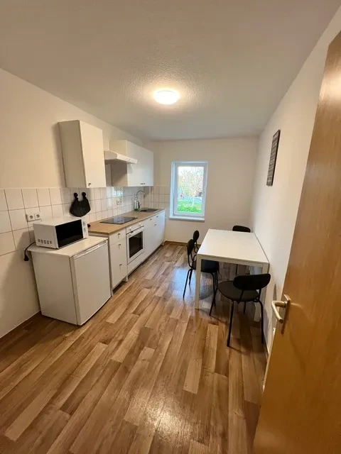 Großes Apartment – moderne Küche mit Essbereich und Holzfußboden Großes Apartment mit moderner Küche und Essbereich, helle Einrichtung und Holzfußboden