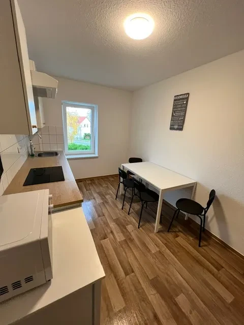 Moderne Küche mit Essbereich und Holzfußboden Apartment mit moderner Küche und Essbereich, helle Einrichtung und Holzfußboden