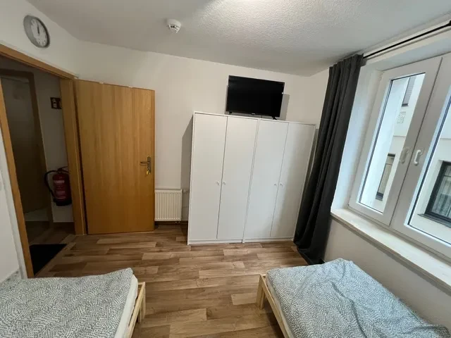 Apartment – Zimmer mit zwei Einzelbetten, Kleiderschrank und TV Apartment mit zwei Einzelbetten, weißem Kleiderschrank und Fernseher
