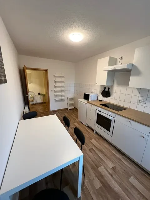 Küche und Essbereich im Apartment Moderne Küche im Apartment mit Esstisch, Herd und Mikrowelle