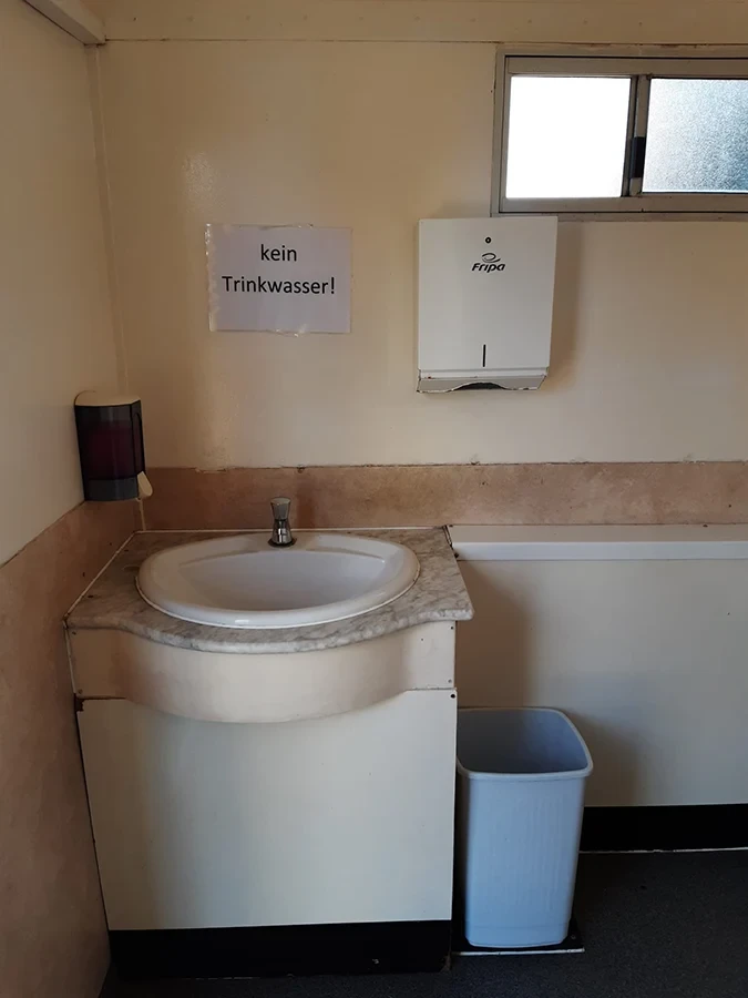 Waschbecken in einer mobilen Toilette von Döring Rohrreinigung und Toilettenvermietung mit Schild 'kein Trinkwasser'
