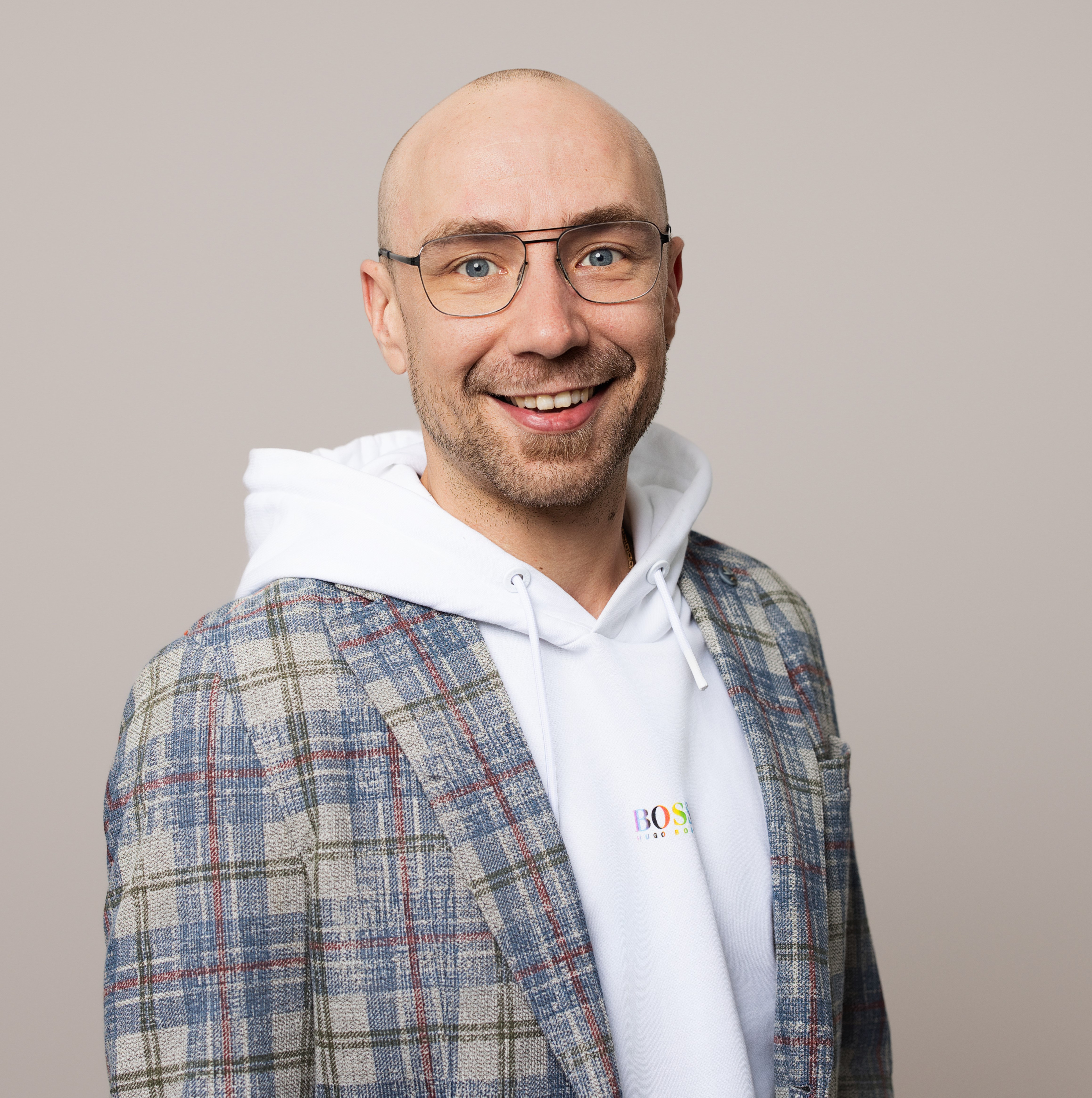 Person mit kariertem Sakko und weißem Hoodie im Fotostudio 358studio für Meershare 2024