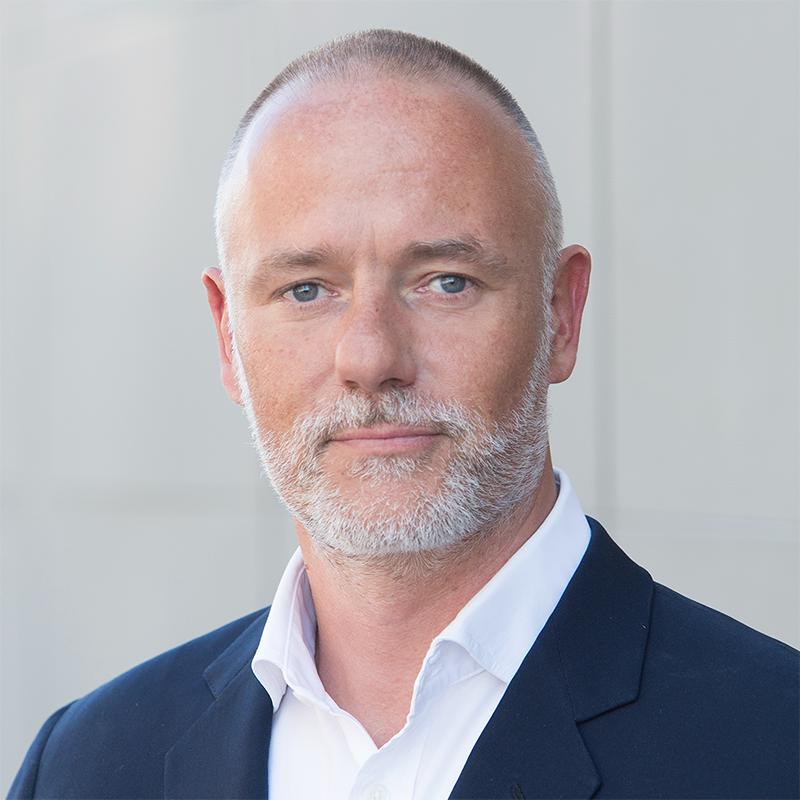 Porträt eines Mannes im Anzug vor neutralem Hintergrund