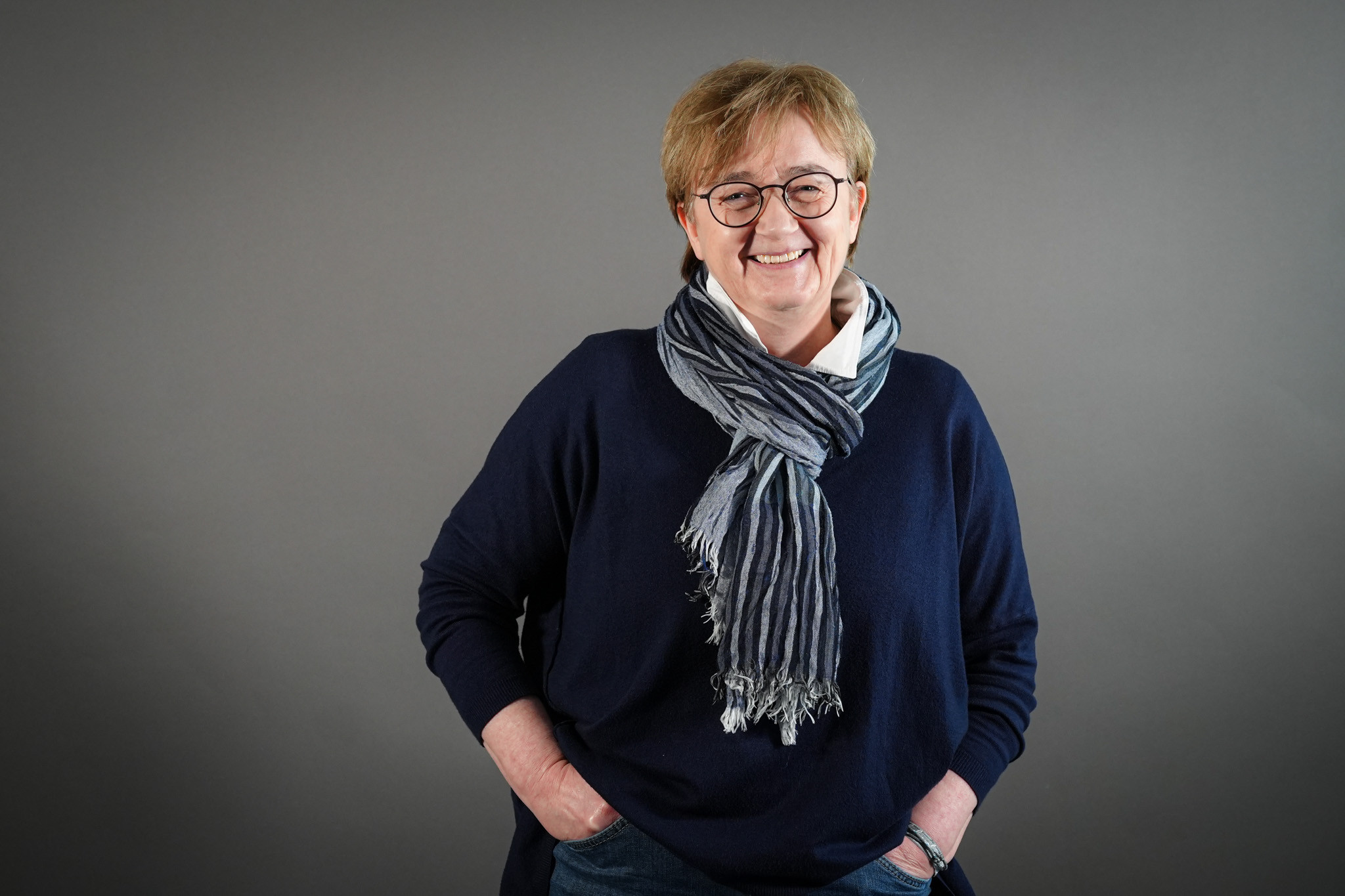 Monika Grabe, Senior Sales Managerin, im Business-Outfit vor grauem Hintergrund