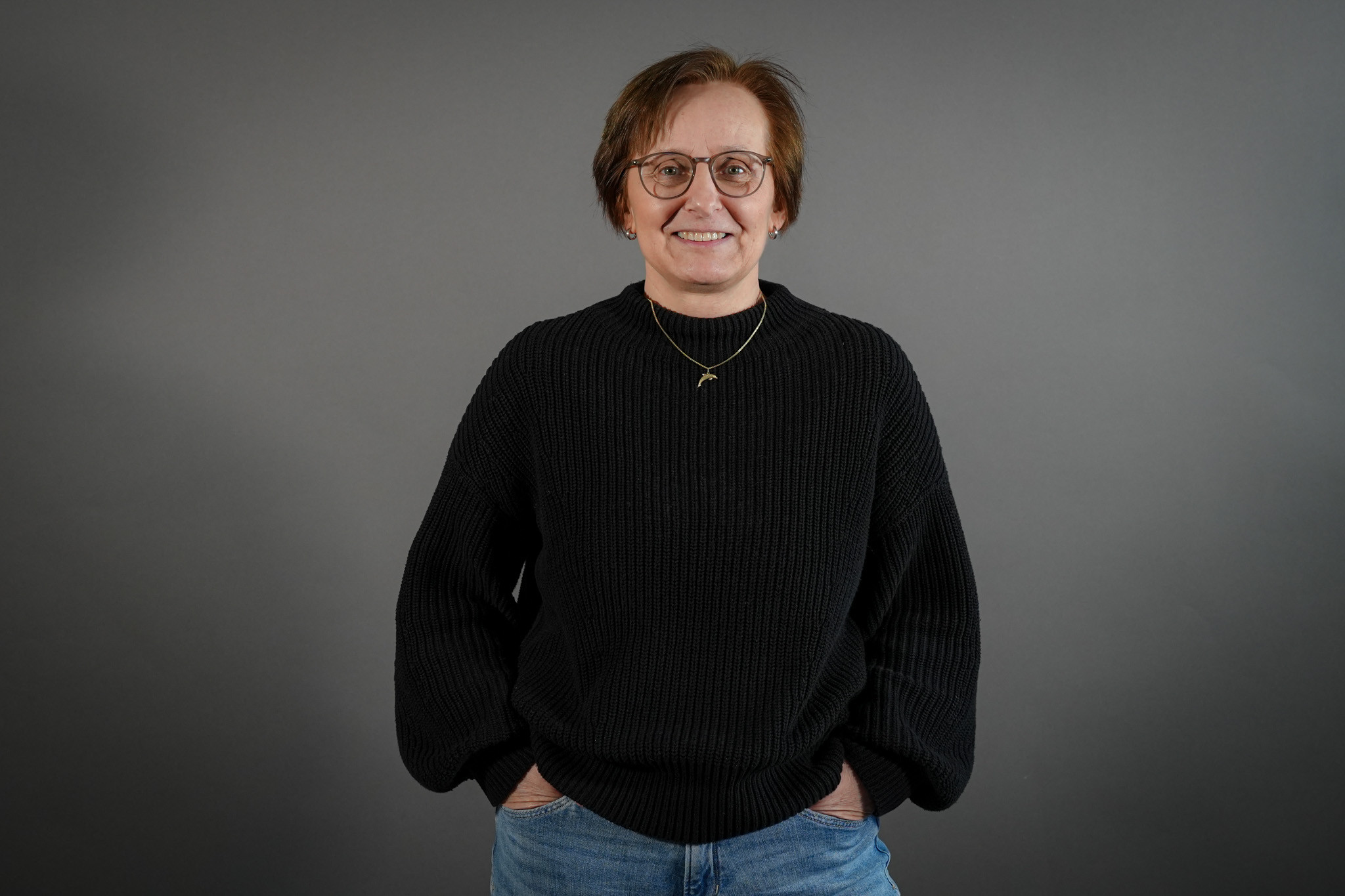 Uta Haffert, Senior Sales Managerin, im schwarzen Pullover vor grauem Hintergrund
