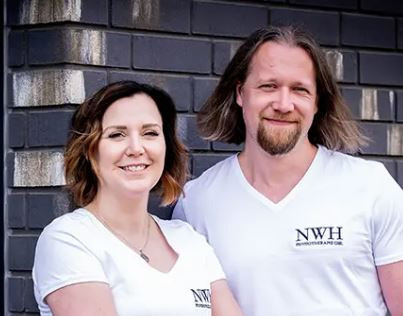 Team von NWH Physiotherapie Magdeburg vor einer Backsteinwand