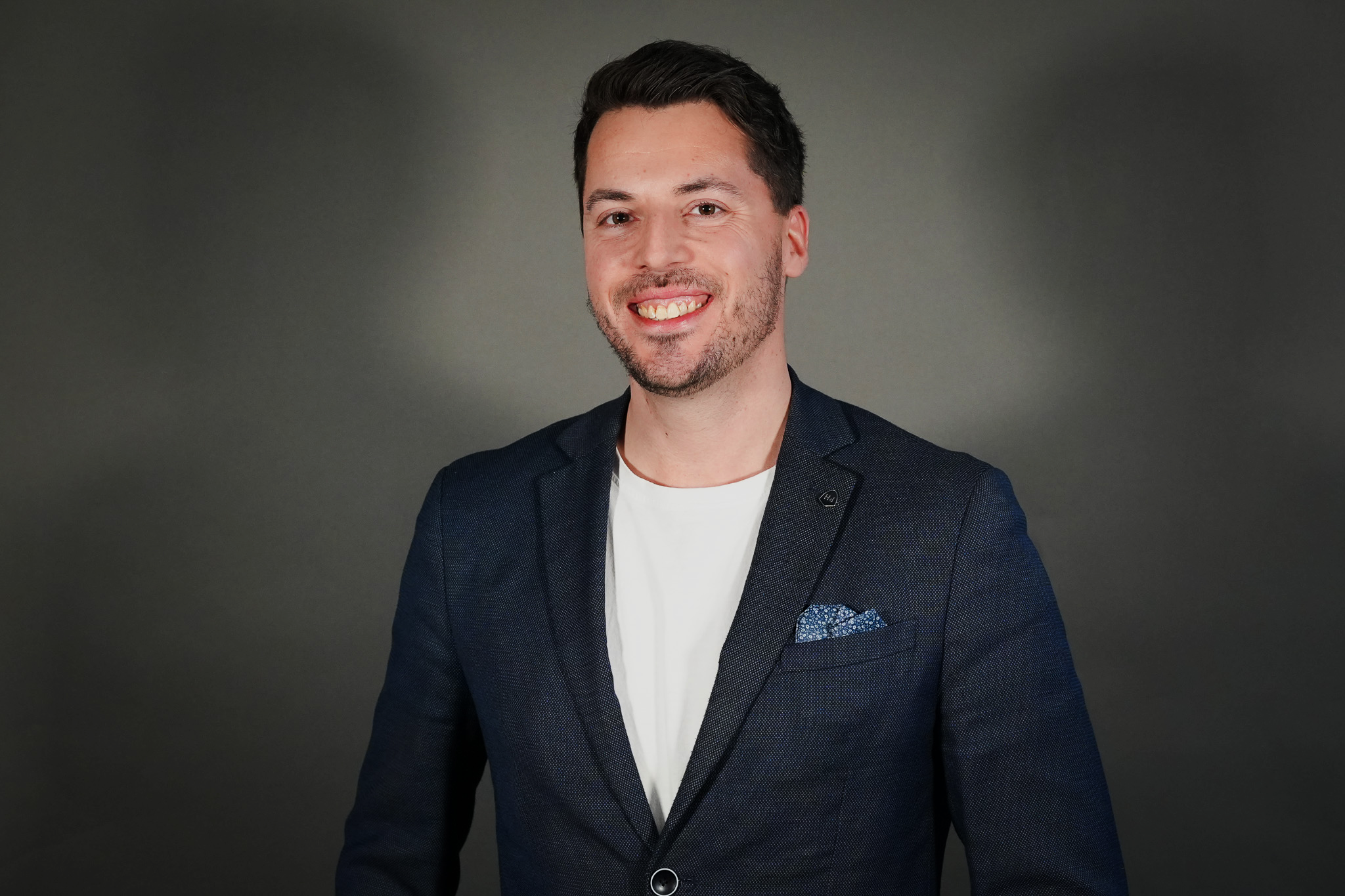 Jochen Seeger im Business-Outfit vor neutralem Hintergrund