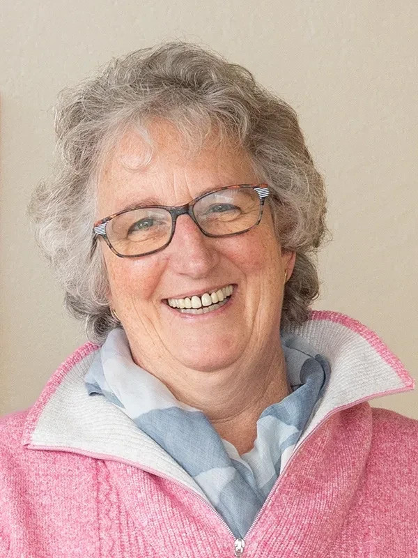 Porträt von Beate Rodgers mit grauen Haaren und rosa Pullover