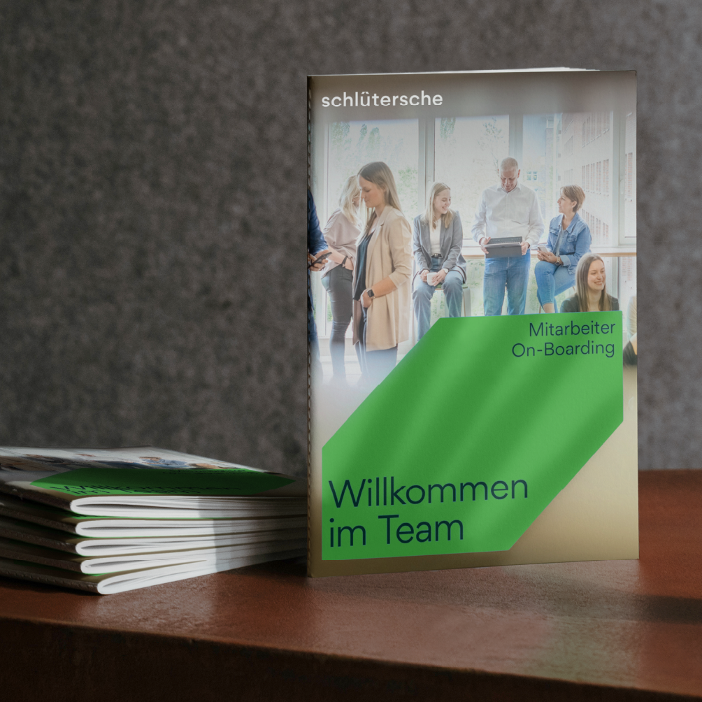 Broschüre 'Willkommen im Team' für Mitarbeiter On-Boarding von Schlütersche auf einem Tisch