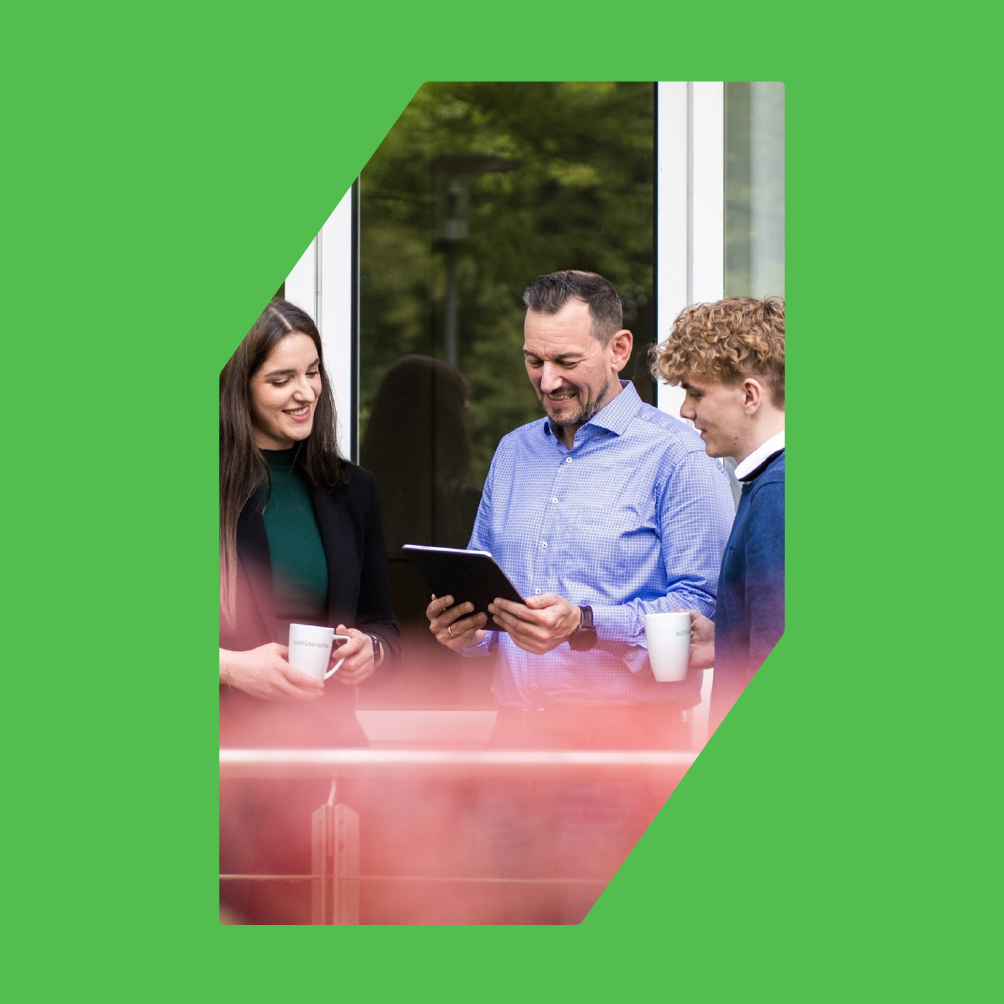 Teammeeting bei sc brandbase, Formensprache und Formenrahmen, Mitarbeiter im Gespräch mit Tablet und Kaffeetassen