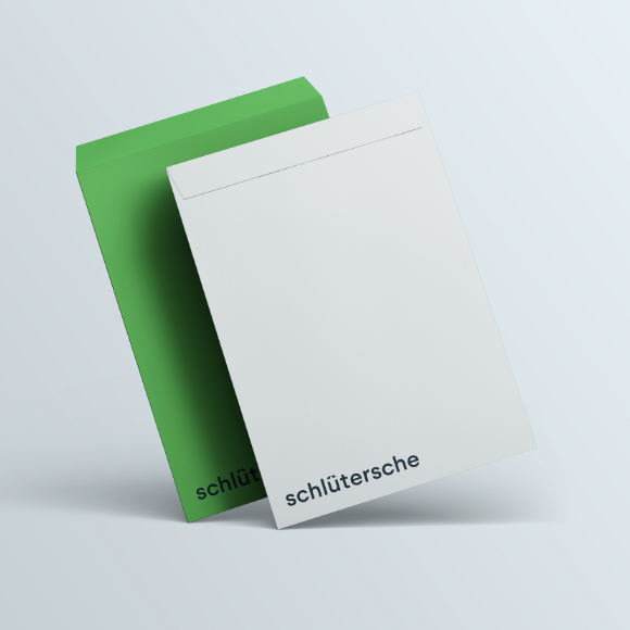 Zwei Kuverts mit Schlütersche-Branding, ein weißes und ein grünes Umschlag
