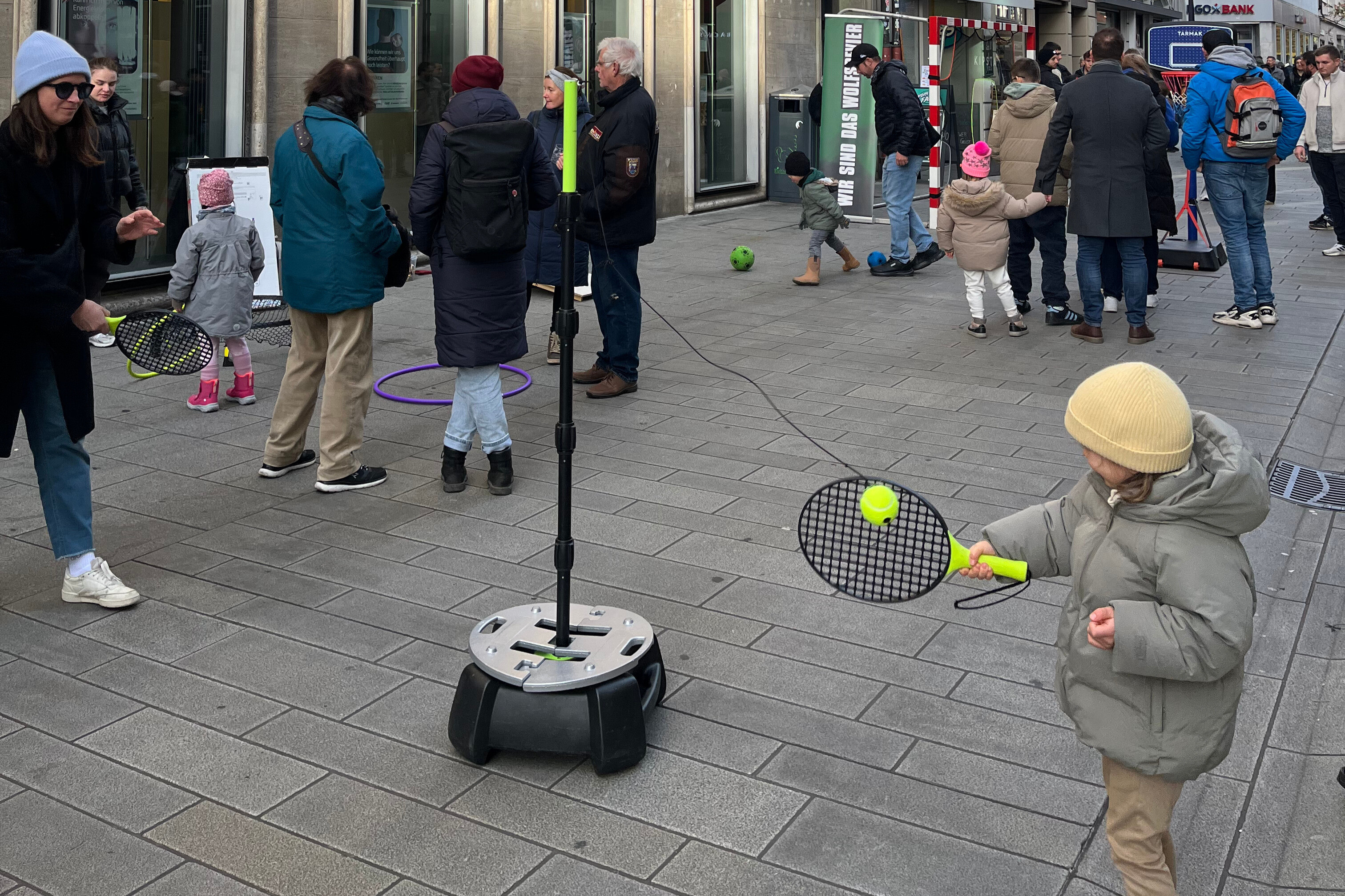 Straßenszene mit Kindern beim Spielen mit Sportgeräten und Bällen Kinder spielen auf einer Straßenszene mit Sportgeräten und Bällen