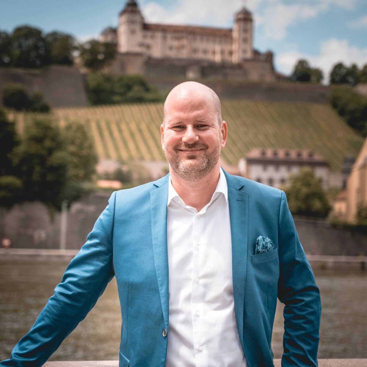 Mann im blauen Sakko vor der Festung Marienberg in Würzburg