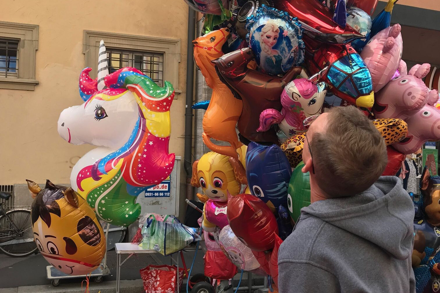 Bunte Luftballons mit Einhorn-Motiv auf einem Straßenfest oder Markt