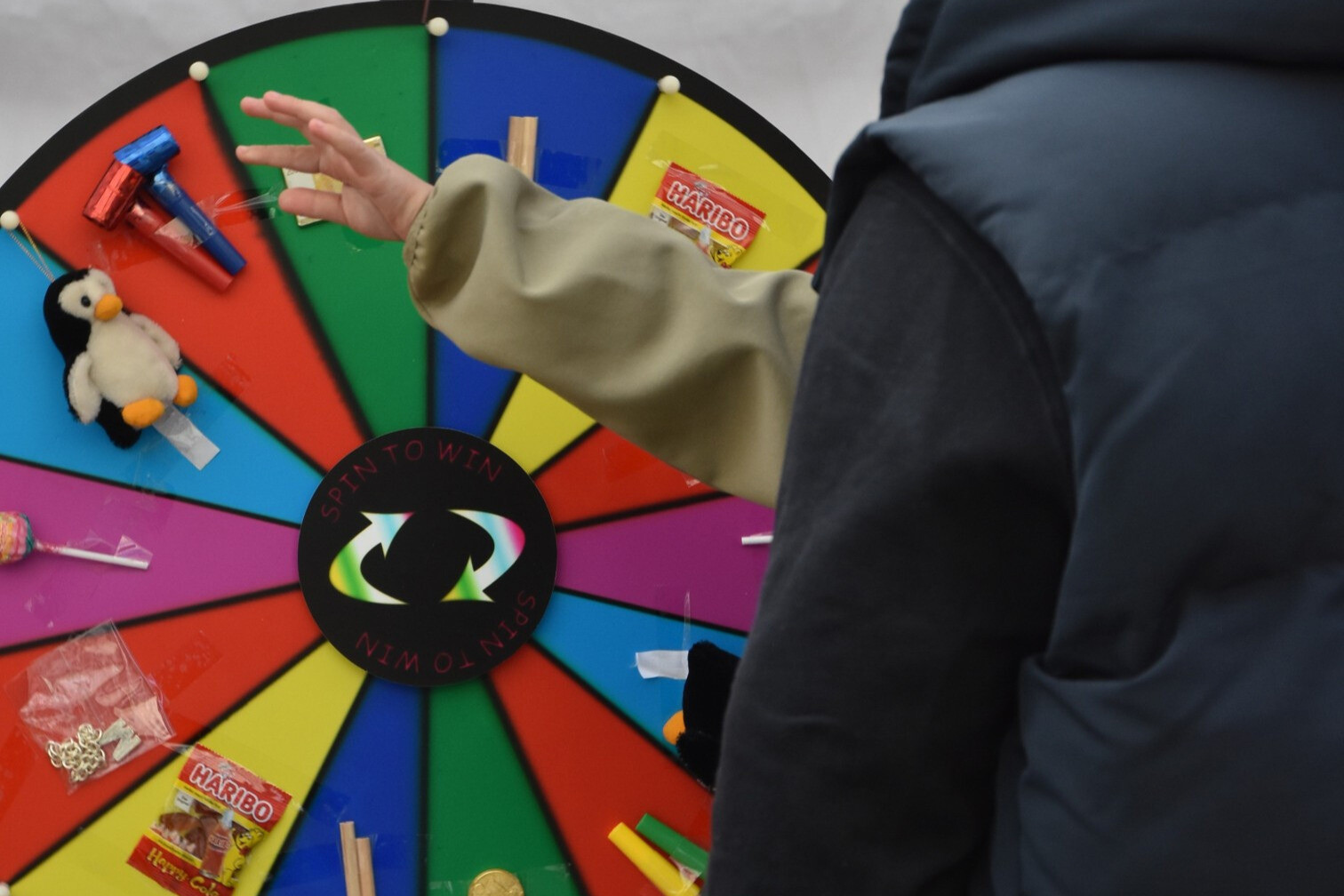 Person dreht an einem bunten Glücksrad mit Haribo-Gewinnmöglichkeit