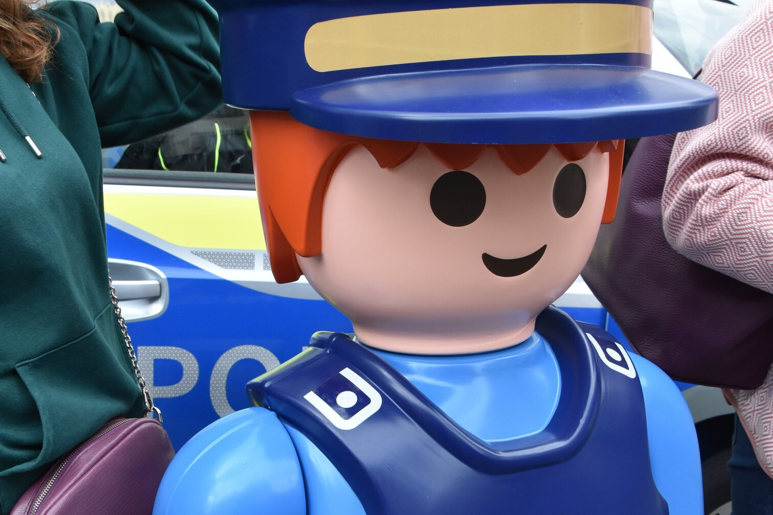 Playmobil-Polizist Figur vor Polizeiauto