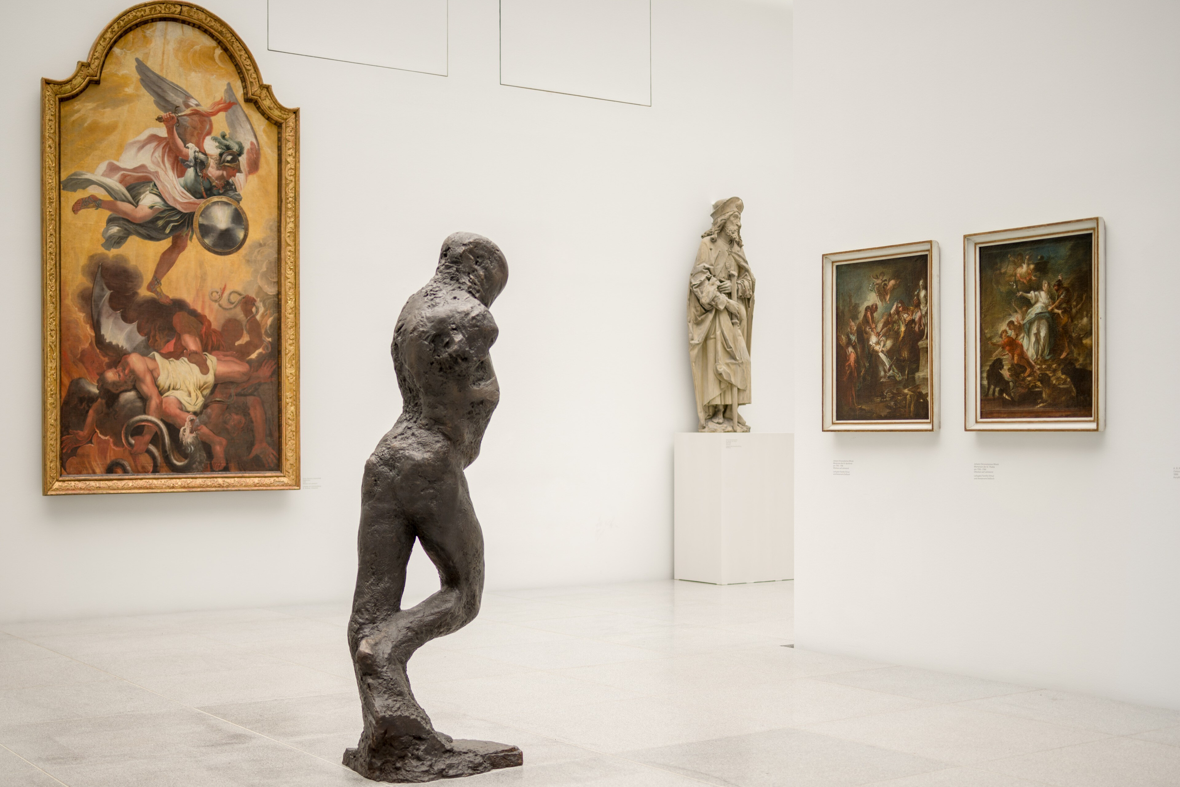 Moderne Skulptur und klassische Kunstwerke in einem hellen Museumsausstellungsraum