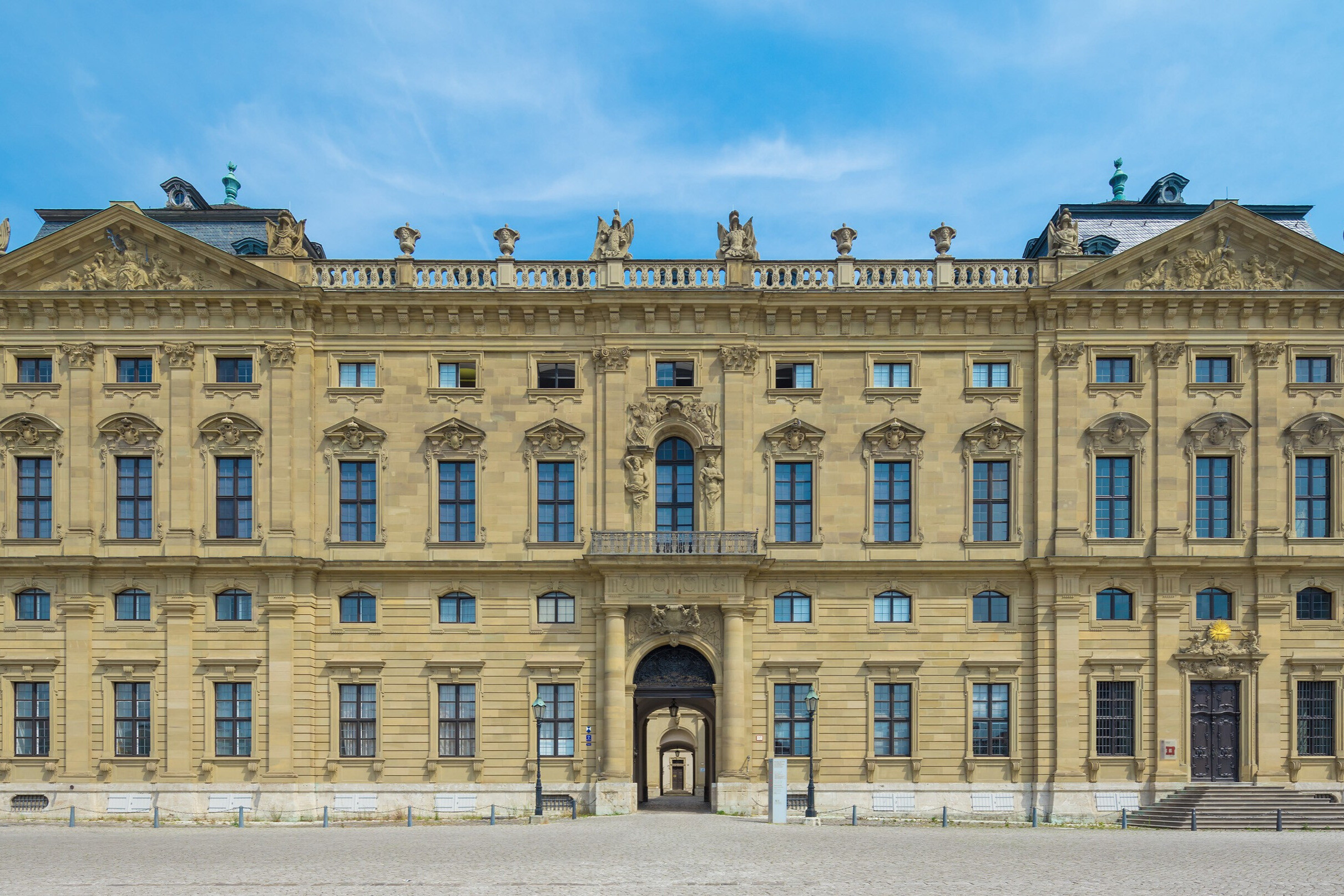 Barocke Fassade eines historischen Schlosses mit zahlreichen Fenstern und Statuen
