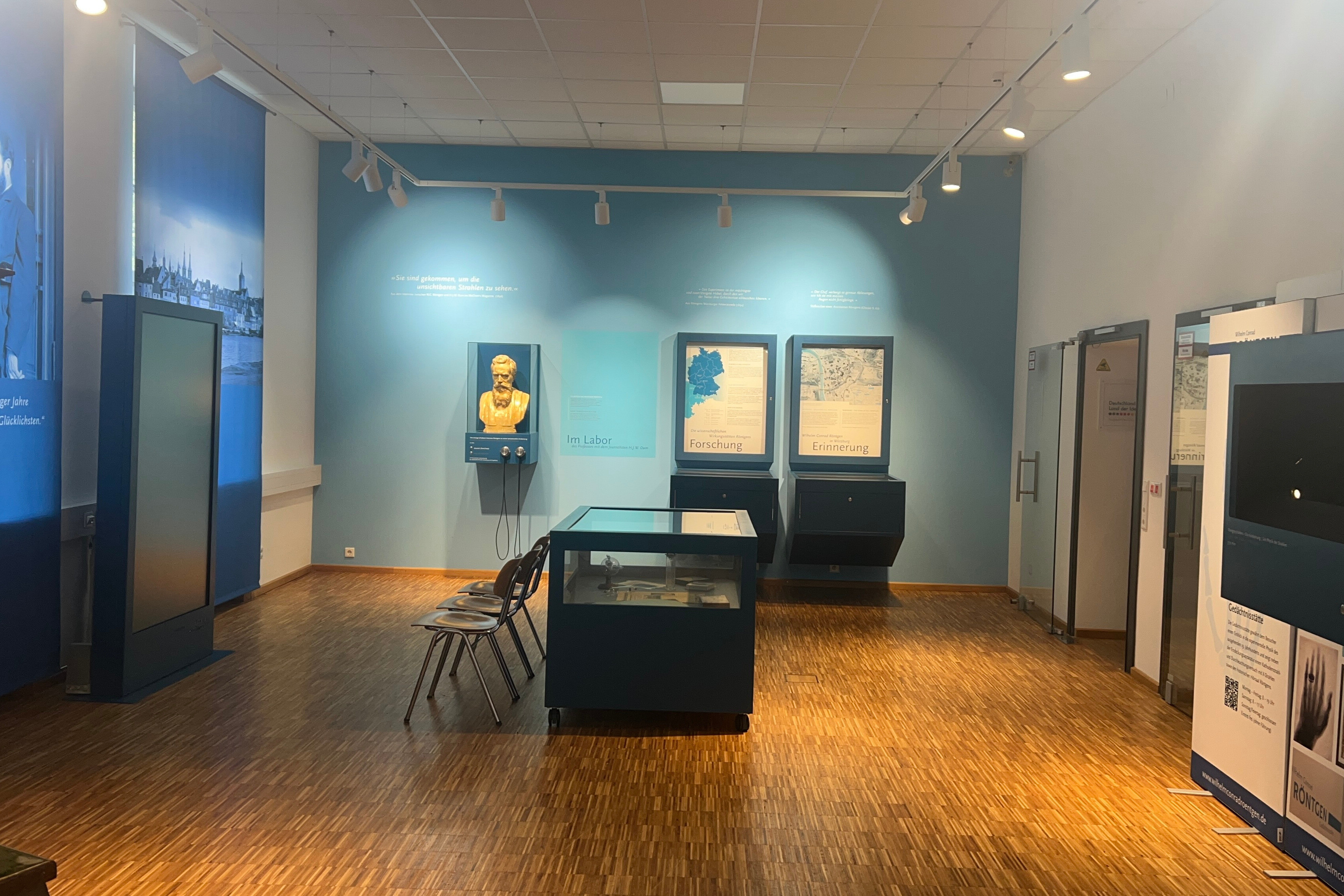 Ausstellung mit Büste, Schautafeln und Vitrine in einem modernen Museum