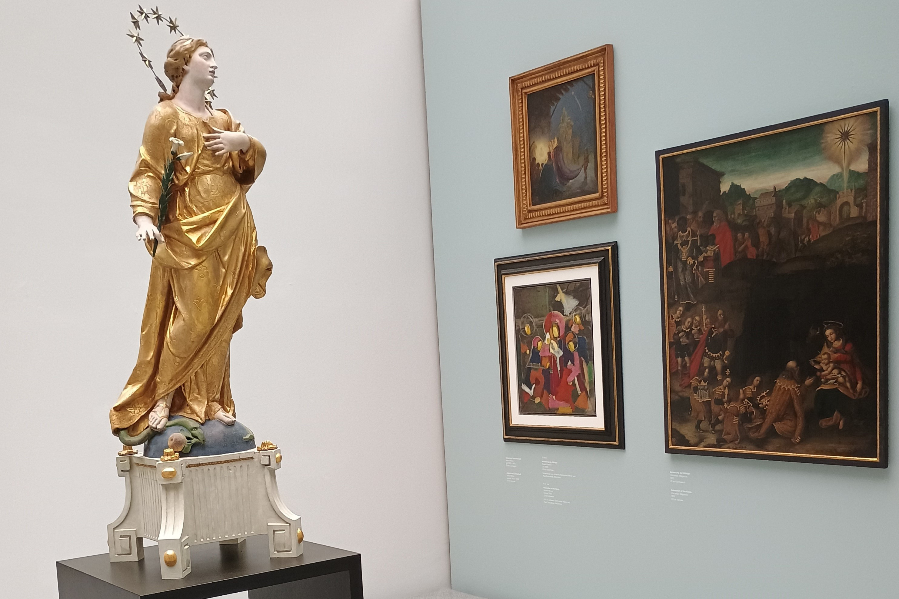 Statue einer Heiligen und Gemälde in einer Kunstausstellung