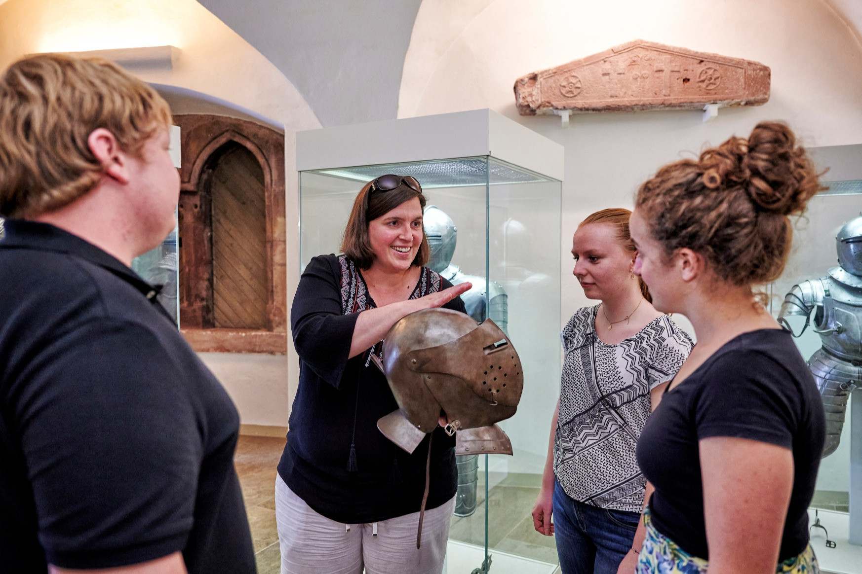 Führung in einem Museum mit mittelalterlicher Ritterrüstung und Helm