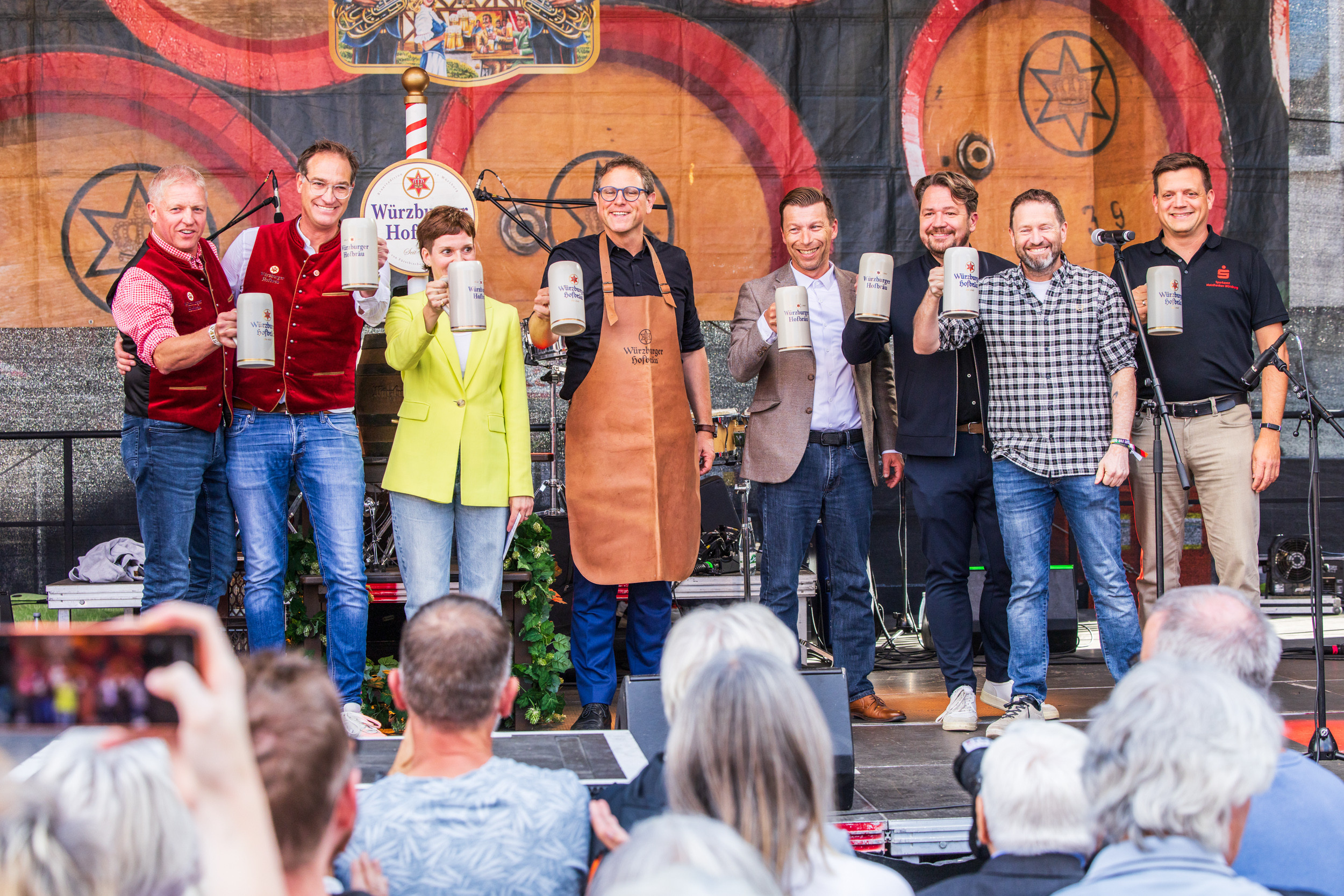 Eröffnung des Würzburger Hofbräu Volksfestes 2026 mit Gästen auf der Bühne beim Anstoßen mit Bierkrügen