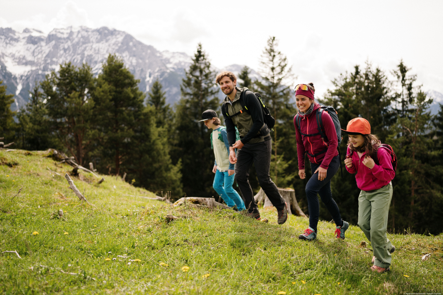 Familie beim Wandern und Entdecken in den Bergen, gemeinsames Zusammensein in der Natur