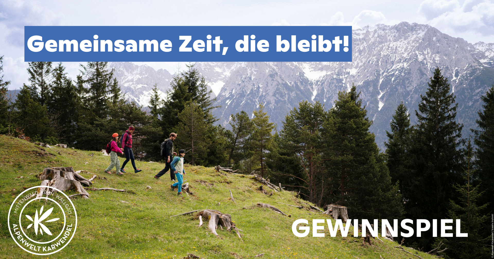 Familienwanderung in den Alpen mit Blick auf verschneite Berge und Wald