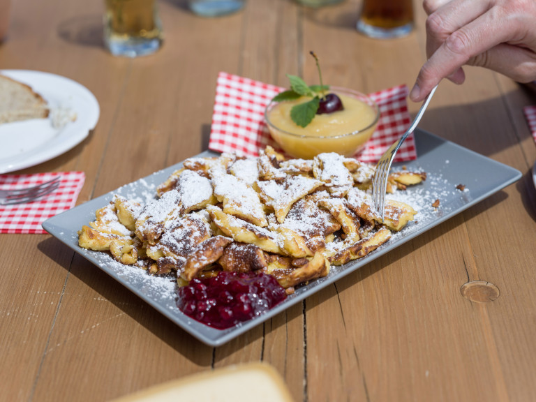 Kaiserschmarrn am Koglweg in Thierbach, Wildschönau – Spezialität für Genießer, Tourismus Wildschönau, Foto Dabernig Kaiserschmarrn am Koglweg in Thierbach, Wildschönau – traditionelle österreichische Mehlspeise mit Apfelmus und Preiselbeeren, serviert auf einer Terrasse, Tourismus Wildschönau, Foto von Dabernig