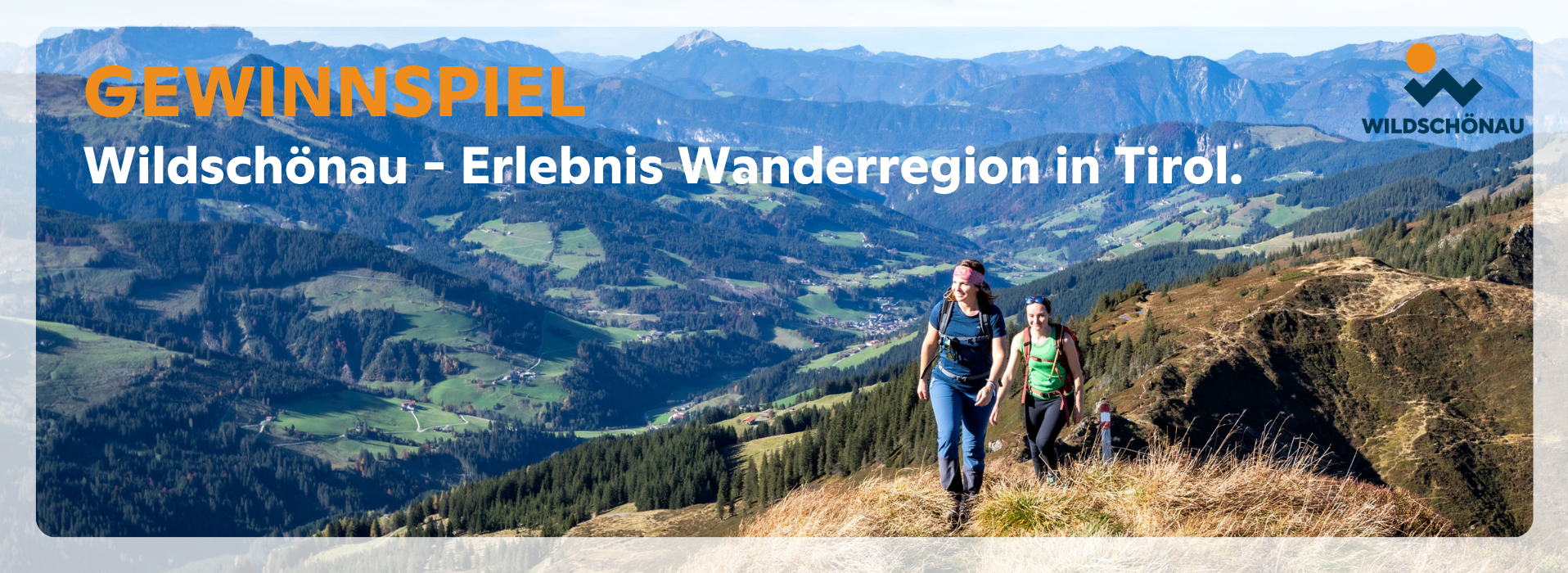 Wanderer in der Erlebnis Wanderregion in den Alpen mit Panoramablick auf Berge und Täler