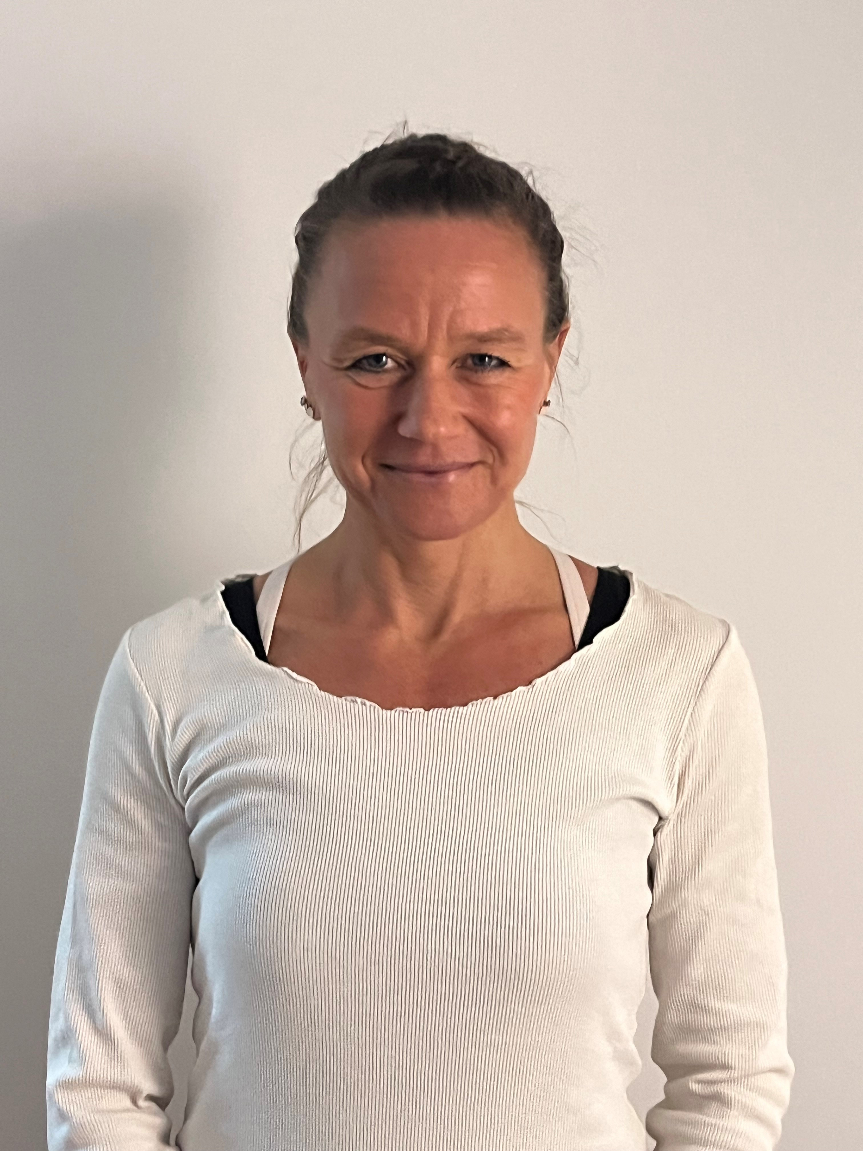 Frau mit weißem Oberteil vor neutralem Hintergrund