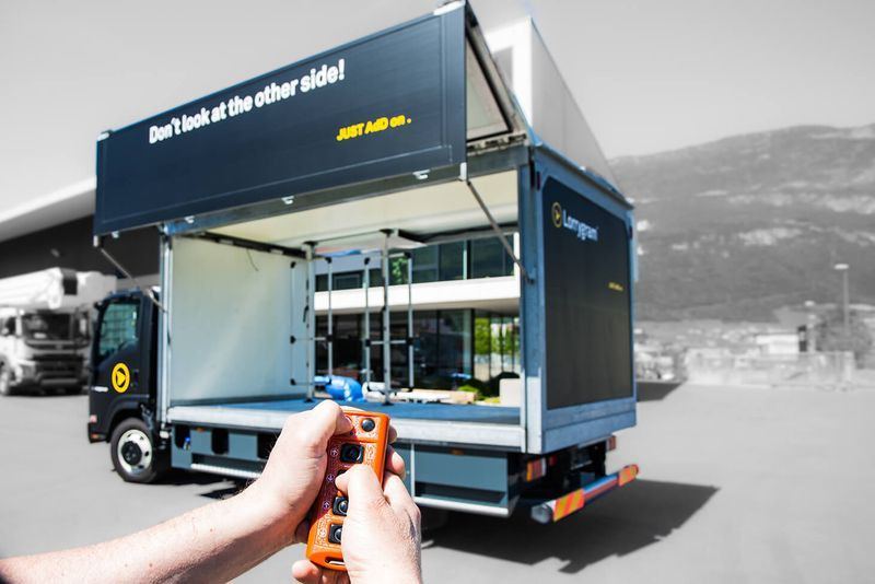 Fernsteuerung eines Lastwagens mit Werbebotschaft auf der Seite, moderner Lkw im Freien