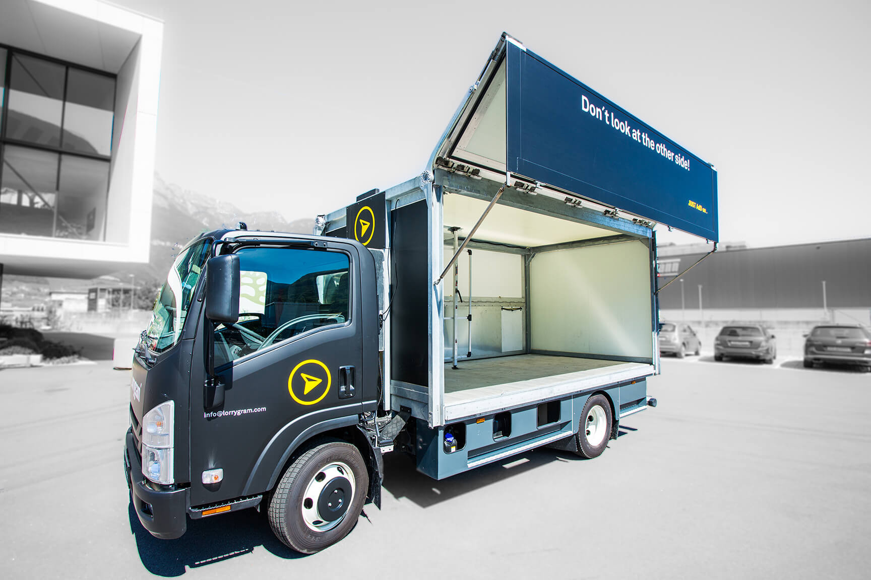 Werbetruck mit geöffneter Seitenklappe und Aufschrift 'Don't look at the other side!'