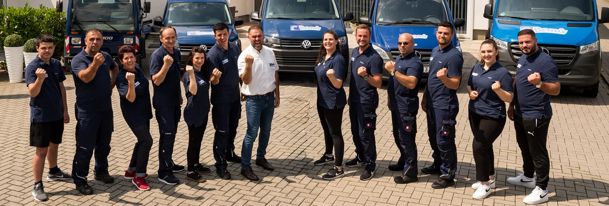 Objektbetreuungsteam vor Firmenfahrzeugen Team der Objektbetreuung vor Firmenfahrzeugen