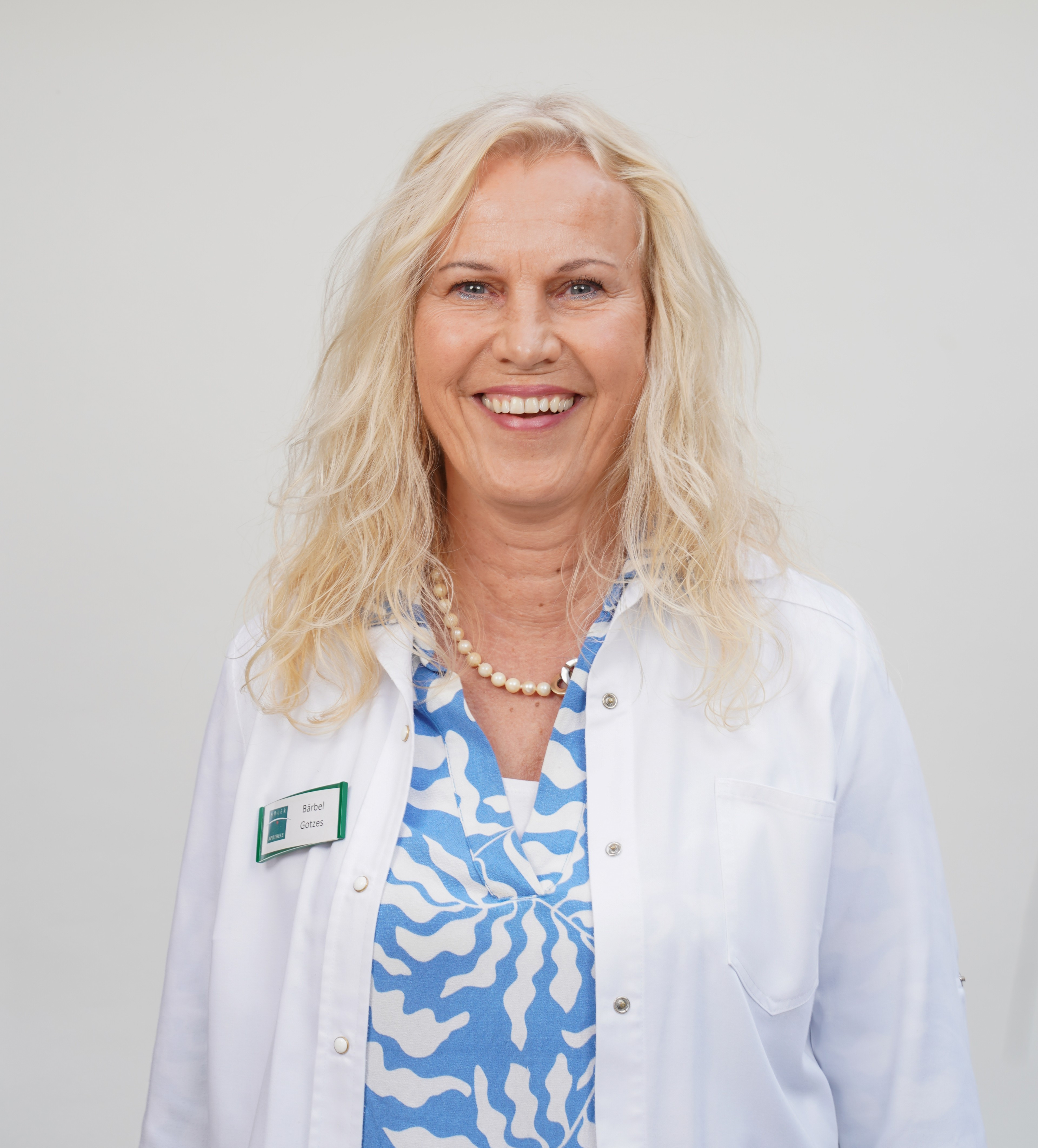 Bärbel Götzes im weißen Kittel mit Namensschild