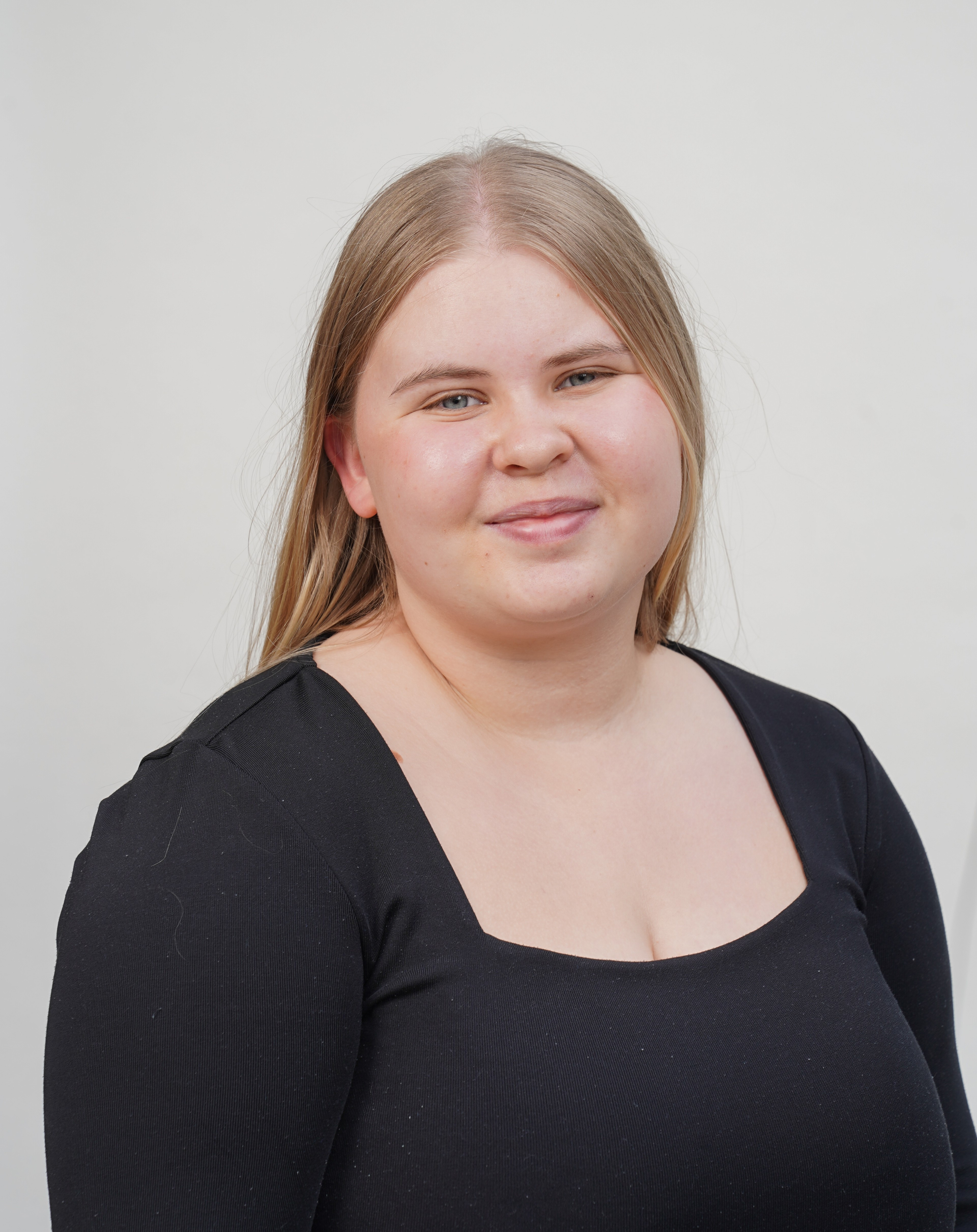 Lina Misera im schwarzen Oberteil vor hellem Hintergrund