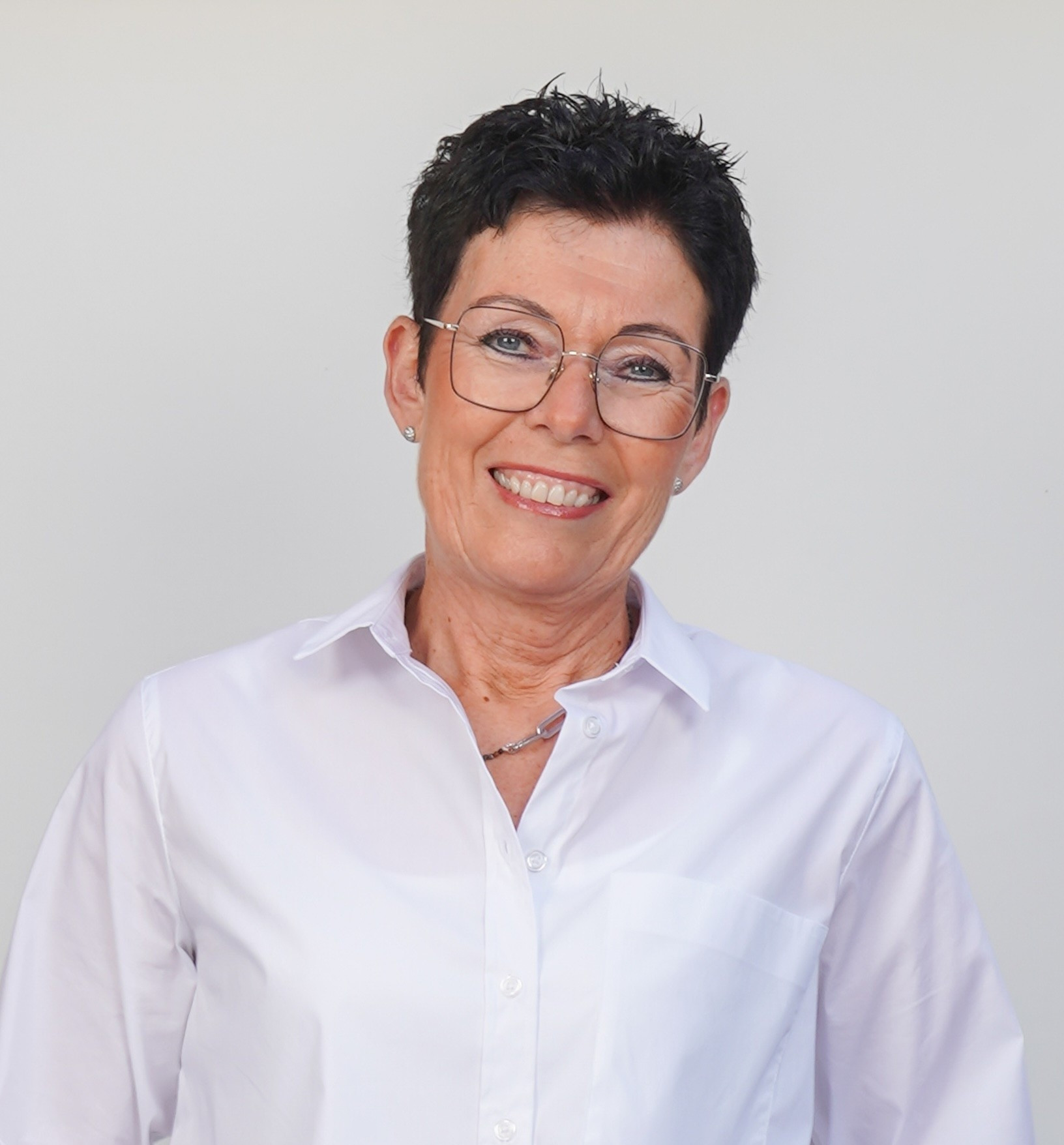 Annemarie Lachmann in weißem Hemd vor neutralem Hintergrund