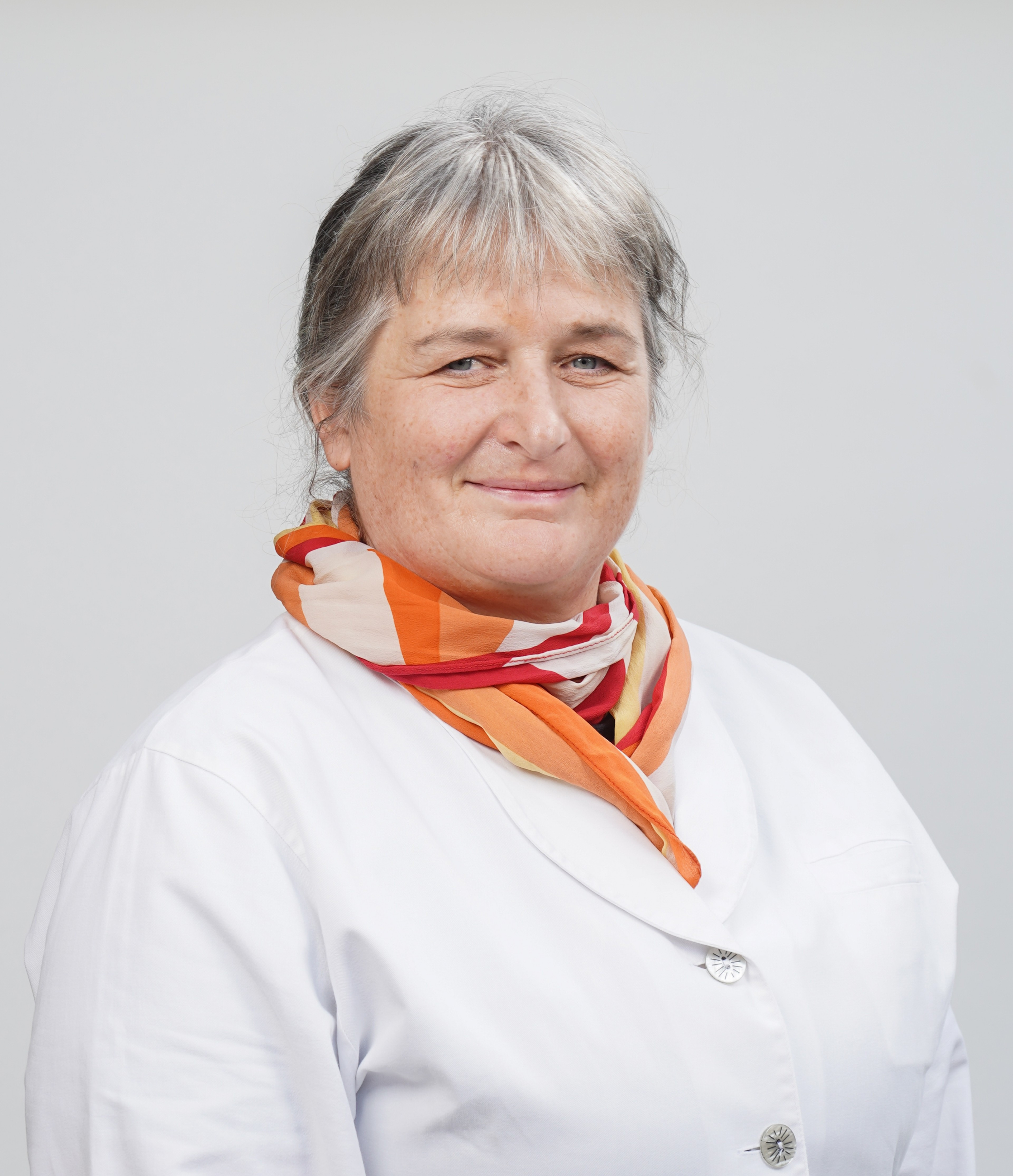 Stephanie Janas im weißen Kittel mit buntem Halstuch